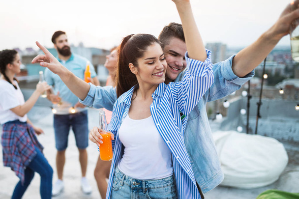 Happy friends having party on top of the roof . Fun, summer, city lifestyle and friendship concept - Foto, Imagen