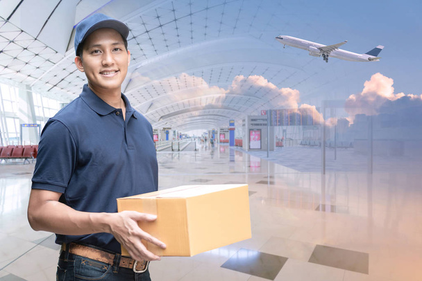 Азіатський доставки чоловік тримає картонну коробку з міжнародним аеропортом фон  - Фото, зображення