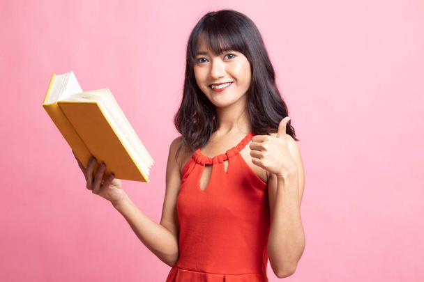Young Asian woman thumbs up with a book. - Photo, image