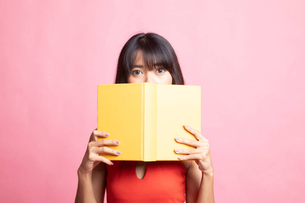 Young Asian woman with a book cover her face. - Foto, imagen