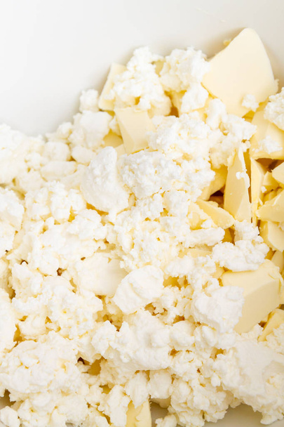 In a mixing bowl are the ingredients butter and cottage cheese f - Фото, зображення