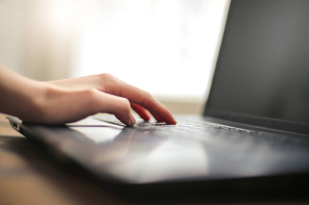 Detalhe de uma mão digitando no teclado de um laptop - Foto, Imagem
