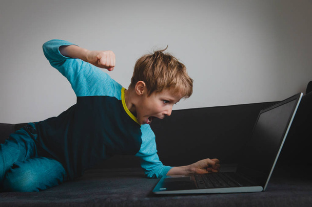 επιθετικό παιδί με φορητό υπολογιστή στο σπίτι, παιδί λάθος αντίδραση στην αποτυχία - Φωτογραφία, εικόνα