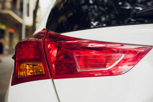 Τα πίσω φώτα ενός σύγχρονου αυτοκινήτου κύρους από μια στενή γωνία. - Φωτογραφία, εικόνα