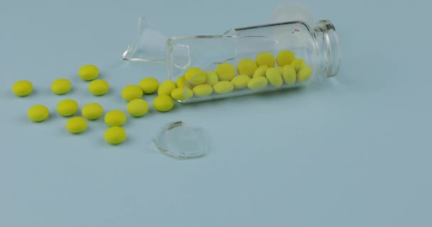 Rikkoutunut lasipurkki, jossa on monia pillereitä ja huumeita sinisellä pohjalla
 - Materiaali, video