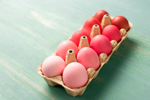 dokulu yüzeyüzerinde karton taşıyıcı boyalı paskalya yumurtaları - Fotoğraf, Görsel