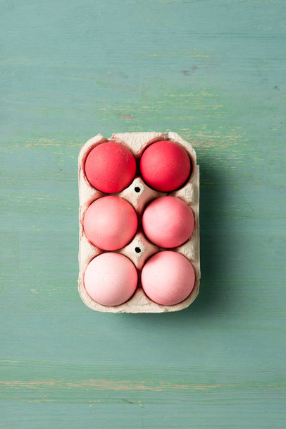 top view of painted easter eggs in cardboard carrier on textured surface - Photo, Image