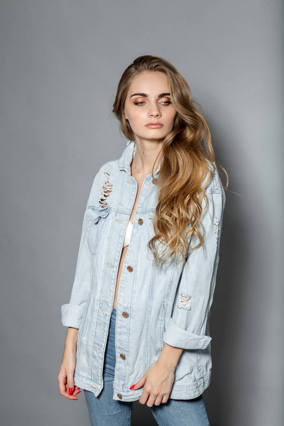 Girl in a denim shirt on a gray background. - Foto, immagini