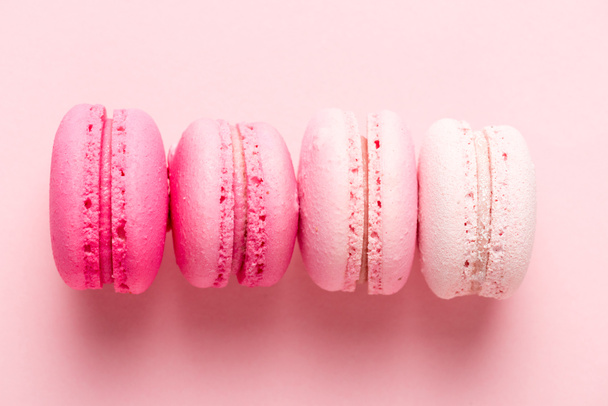 top view of colorul macarons on pink surface - Foto, Bild