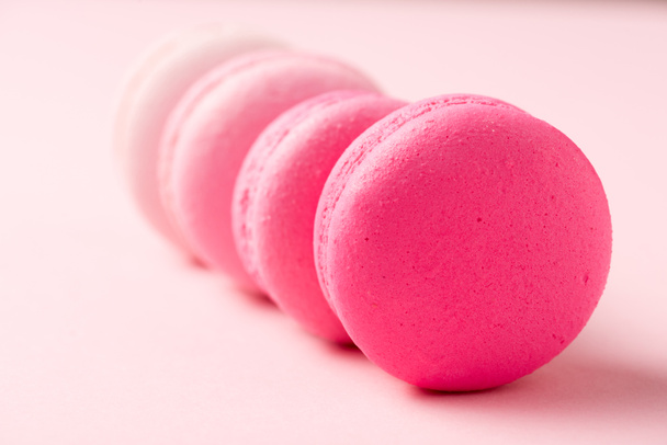 вибірковий фокус солодких барвистих макаронів на рожевій поверхні
 - Фото, зображення