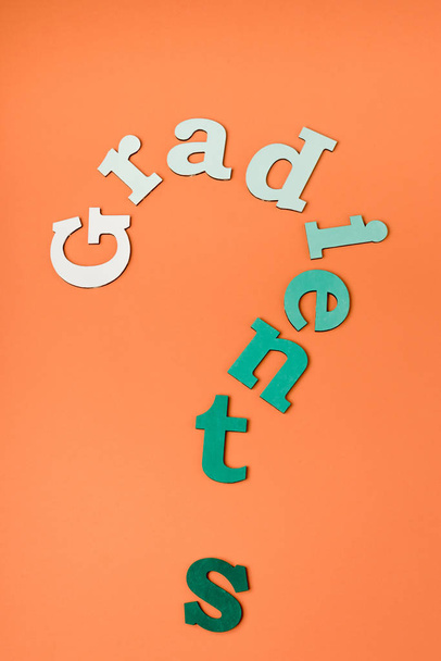Draufsicht auf bunte Buchstaben auf orangefarbener Oberfläche - Foto, Bild