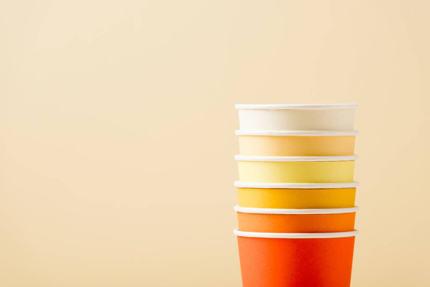 bright colorful disposable cups isolated on beige background - Фото, зображення