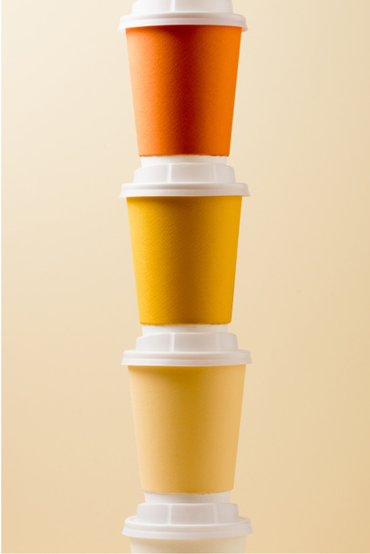 bright colorful disposable cups isolated on beige background - Φωτογραφία, εικόνα
