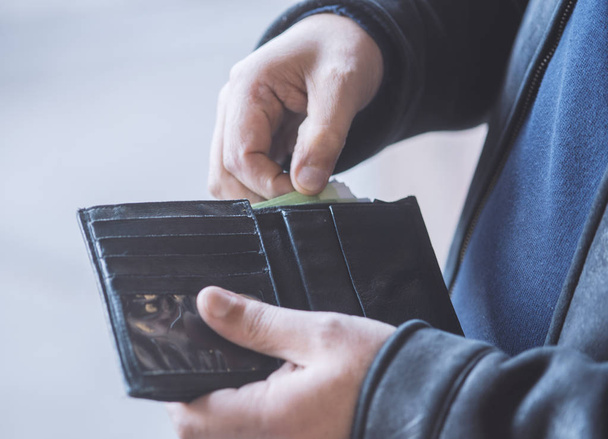 man pulls money out of his wallet - Photo, image