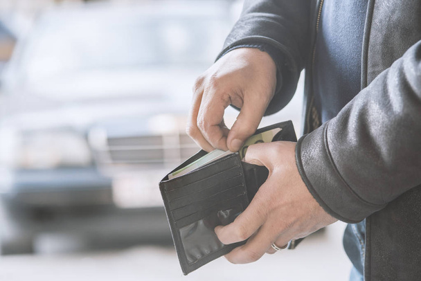 man pulls money out of his wallet - Φωτογραφία, εικόνα