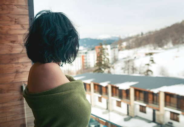 Μελαχρινή γυναίκα στο μπαλκόνι το χειμώνα - Φωτογραφία, εικόνα
