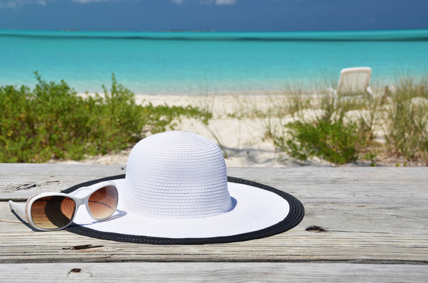 Шляпа и солнцезащитные очки на пляже Эксума, Багамы
 - Фото, изображение