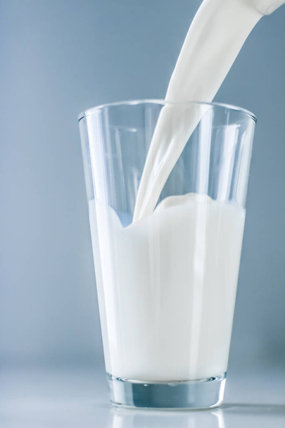 Światowy dzień mleka, wylewając się do szklanki na marmurowym stole - Zdjęcie, obraz