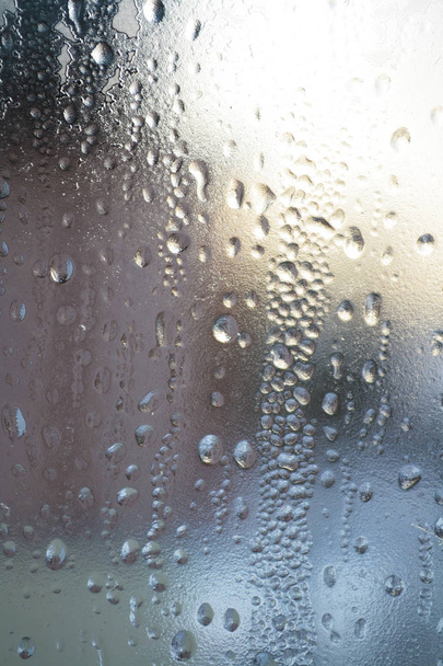 Krople deszczu na powierzchni okularów okiennych z pochmurne tło. Naturalny wzór krople deszczu zachmurzone tło. - Zdjęcie, obraz