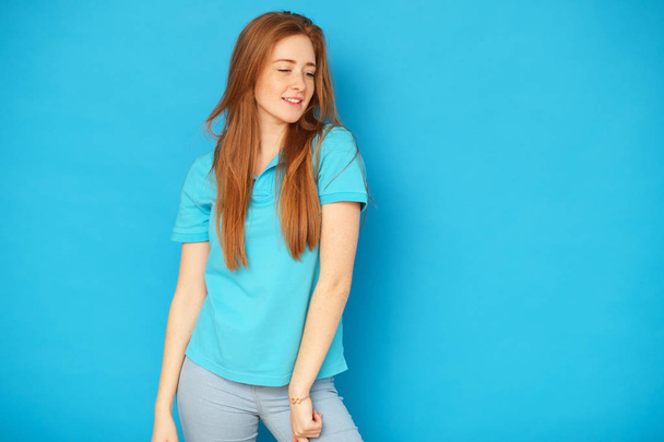 Happy and cute girl standing on blue background. - Foto, Imagen