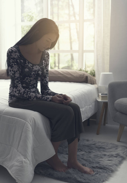 Λυπημένη μοναχική γυναίκα που κάθεται στο κρεβάτι - Φωτογραφία, εικόνα