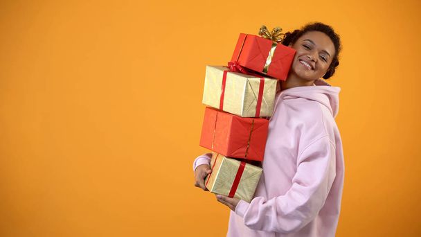 Joyful female student holding present boxes, shopping sale, holiday celebration - 写真・画像
