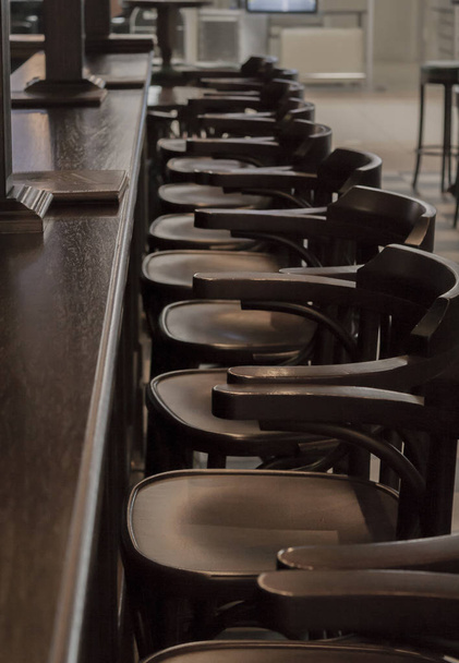 Klasyczny bar/pub Stoiska i rząd drewnianych stołki barowe przed nim - Zdjęcie, obraz