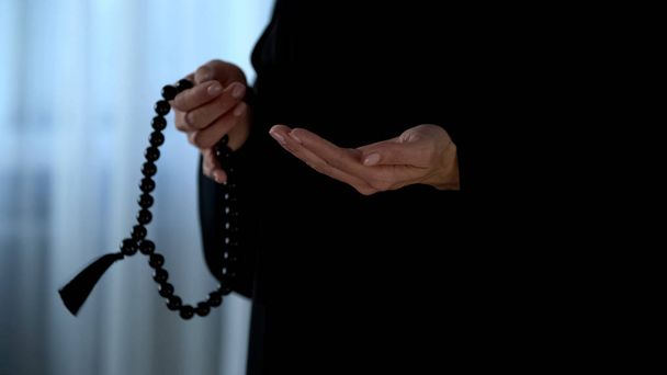Arab female in hijab counting prayers by rosary in hand, religious forgiveness - Fotografie, Obrázek