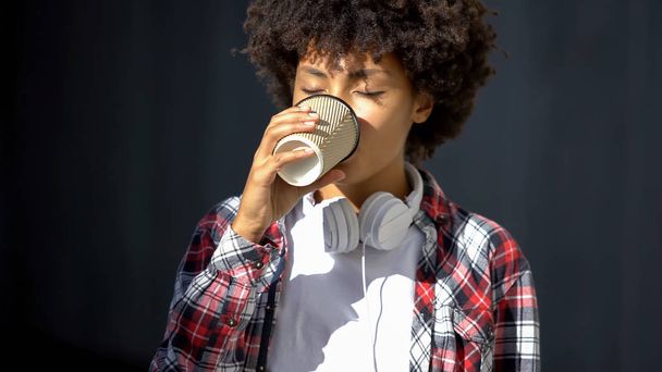 Beautiful afro-american lady drinking coffee outdoor, refreshing beverage - 写真・画像
