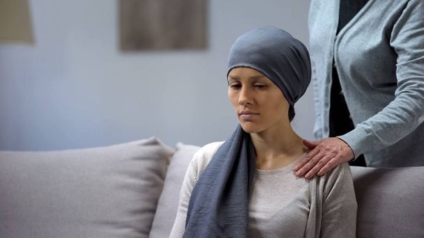 Mother putting hand on shoulder of her upset daughter with cancer, support - Foto, afbeelding
