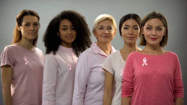 乳がんと闘うピンクの服やリボンを身に着けている女性のグループ - 写真・画像