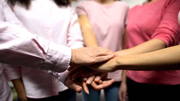 Krebskranke Frauen in rosa Hemden, die Hände zusammenlegen, unterstützen, Feminismus - Foto, Bild