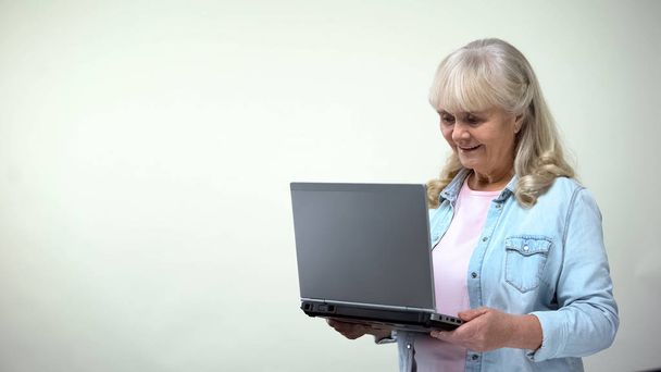 Elderly female communicating with children on laptop, modern technologies - Foto, imagen