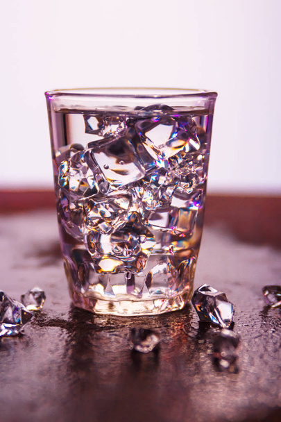 Glass of pure water with ice cubes.Abstract dynamic backdrop for your design - Φωτογραφία, εικόνα