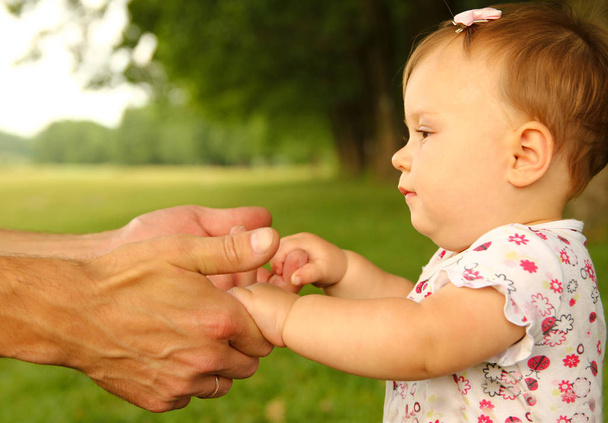  rodič drží za ruku malé dítě - Fotografie, Obrázek