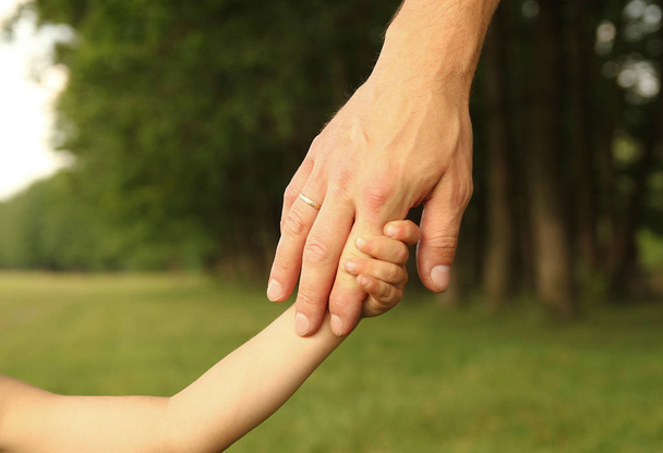  rodič drží za ruku malé dítě - Fotografie, Obrázek