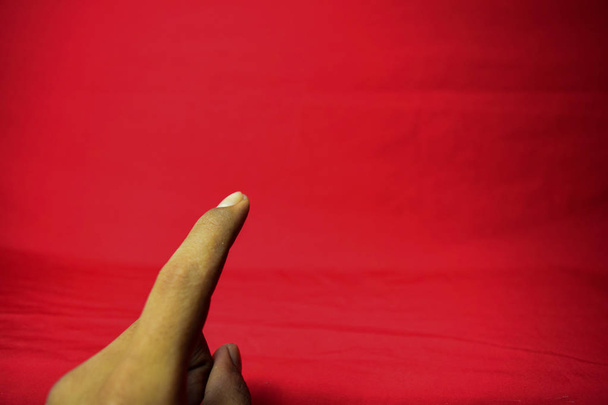 Main avec doigt levé sur le fond rouge
 - Photo, image