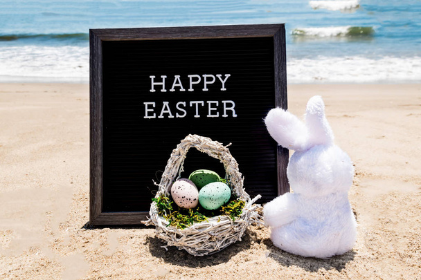 Boldog Húsvét tengerpart háttér-val fekete fedélzet és nyuszi  - Fotó, kép