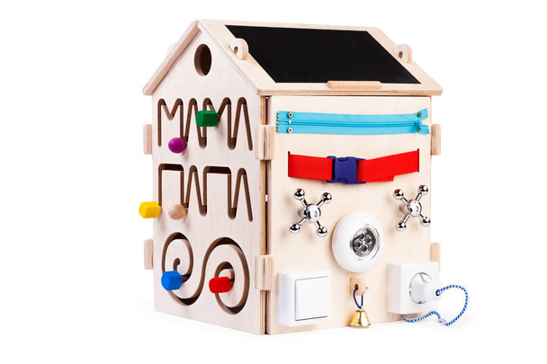 Houten eco-vriendelijke drukke boardhouse - educatief speelgoed voor kinderen, baby 's op een witte geïsoleerde achtergrond, bestaande uit veelkleurige houten puzzelstukjes, doolhof, gear, sorteerder, schakelaars, stopcontacten, watermixers - Foto, afbeelding