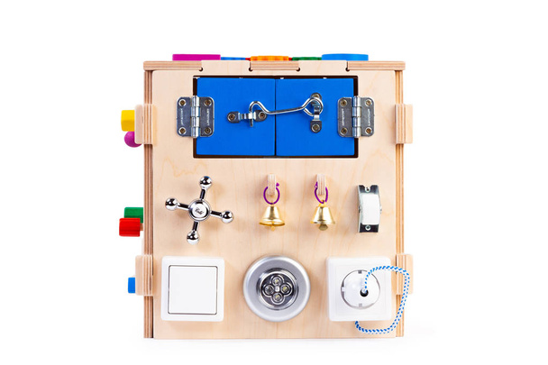 Wooden eco-friendly busy board house - educational toy for children, babies on a white isolated background, consisting maze, gear, sorter, switches, sockets, water mixers, bell - Photo, Image
