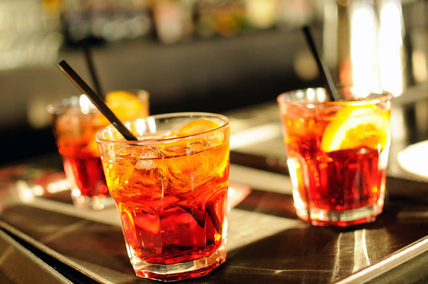 Три стакана коктейлей со льдом на барной стойке
 - Фото, изображение