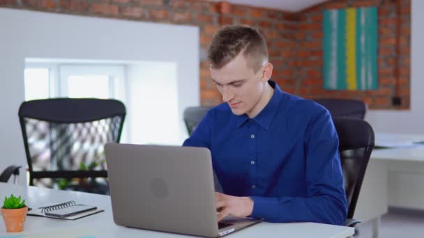 Επιχειρηματίας που κάθεται στο γραφείο, χρησιμοποιώντας φορητό υπολογιστή, ολοκληρώνει το έργο - Πλάνα, βίντεο