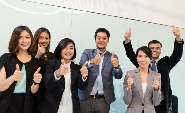 Возбужденные деловые люди, показывающие большой палец в офисе
 - Фото, изображение