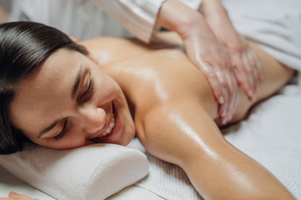 Женщина наслаждается массажем спины
 - Фото, изображение