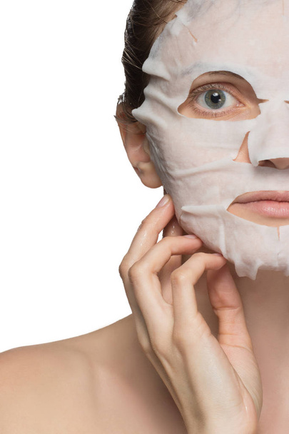 Красивая молодая женщина наносит косметическую маску на лицо
 - Фото, изображение