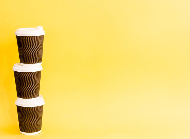 paper coffee cup on a yellow background - Фото, изображение