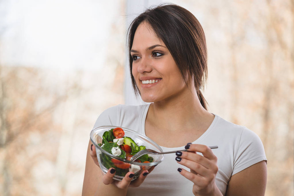 Portrait rapproché de jeune femme mangeant de la salade
 - Photo, image