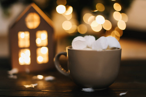 Christmas coffee cup with marshmallows. Still life on dark background. New Year's lights and decorations - Foto, imagen