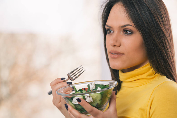 Портрет молодой женщины, держащей здоровый свежий салат
 - Фото, изображение