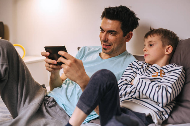 father and son playing games on tablet at home - Foto, Imagem